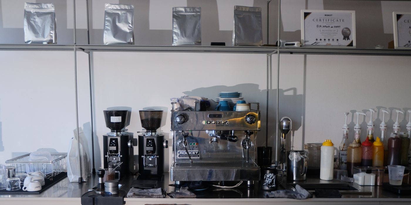 Bar espresso Roket dengan mesin espresso, grinder dan rak biji kopi